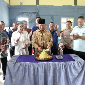 Pj Bupati OKU lakukan pemotongan Tumpeng pada HUT ke-7 Kecamatan Kedaton Peninjauan Raya. Foto Humas Pemkab OKU.