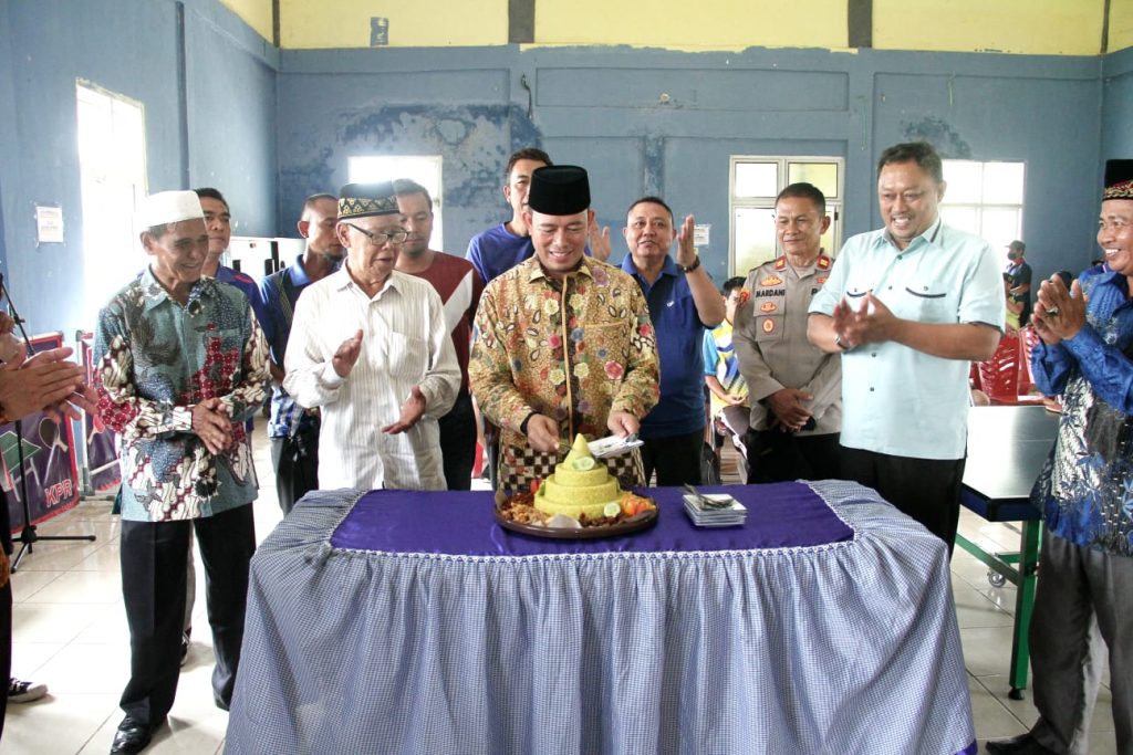 Pj Bupati OKU lakukan pemotongan Tumpeng pada HUT ke-7 Kecamatan Kedaton Peninjauan Raya. Foto Humas Pemkab OKU.