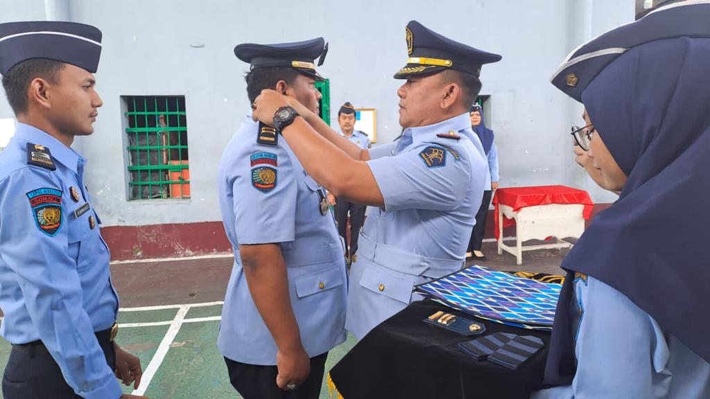 Kalapas Muaradua Kemenhumkan Sumsel Reza Yudhistira Kurniawan menyematkan tanda pangkat III B kepada Kasubsi Giatja Lapas Muaradua, Kresna Hadi Wibowo. Foto dokumen Lapas Muaradua.