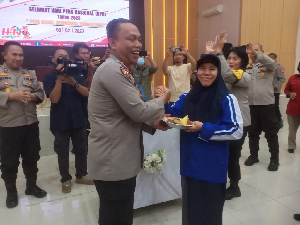 Kapolres OKU AKBP Arif Harsono SIK MH memberikan potongan nasi tumpeng kepada jurnalis paling senior di OKU Leni Juwita (sriwijaya Post) pada perayaan HPN tahun 2023 di Gedung Multimedia Wicaksana Laghawa Polres OKU Rabu ( 8/2/2023). Foto Kanalberita.id / Apriansyah