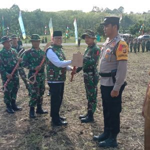 Pj Bupati OKU H Teddy Meilwansyah SSTP MM MPd menyerahkan alat kerja kepada perwakilan personal Satgas V TMMD KE-117 di Desa Karang Endah Kecamatan Lengkiti Kabupaten OKU. Foto Kanalberita.id / Apriansyah