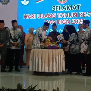 PJ Bupati OKU H Teddy Meilwansyah SSTP MM MPd memoteng nasi tumpeng pada HUT PGRI ke-78 dan HGN tahun 2023 di gedung Kesenian Baturaja sabtu (15/11/2023). Kanalberita.id / Apriansyah