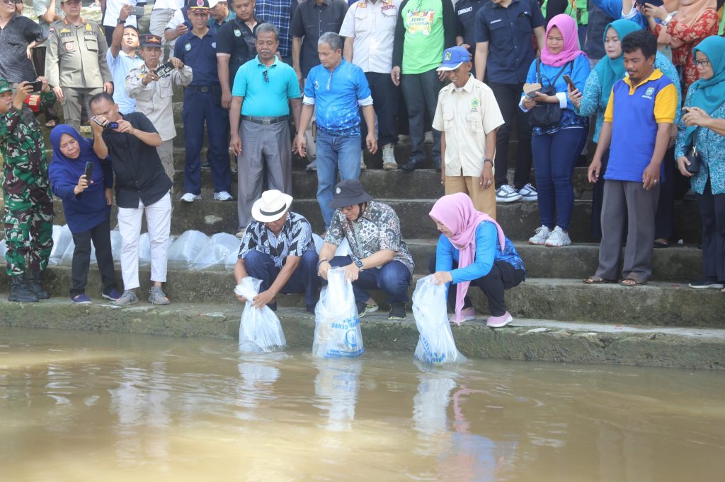 Penjabat Bupati OKU H Teddy Meilwansyah SSTP MM MPd bersama Kepala Dinas Perikanan OKU Ir Hj Tri Aprianingsih menebar bibit ikan di periaran Sungai OKU. Kanalberita.id / Edo