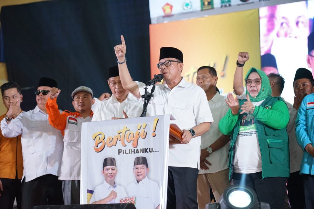 Pasangan balon bupati-wakil bupati OKU 2024 H Teddy Meilwansyah dan H Marjito Bachri berjalan kaki di tengah-tengah massa yang mengiringi ke GOR untuk deklarasi. Foto dokumen BERTAJI