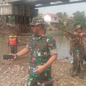 Ratusan personil TNI bersama OPD terkait di jajaran Pemkab OKU berjibaku turun ke Sungai Ogan untuk membersihkan sampah yang terperangkap di tiang-tiang penyangga jembatan. Foto Kanalberita.id / Edo