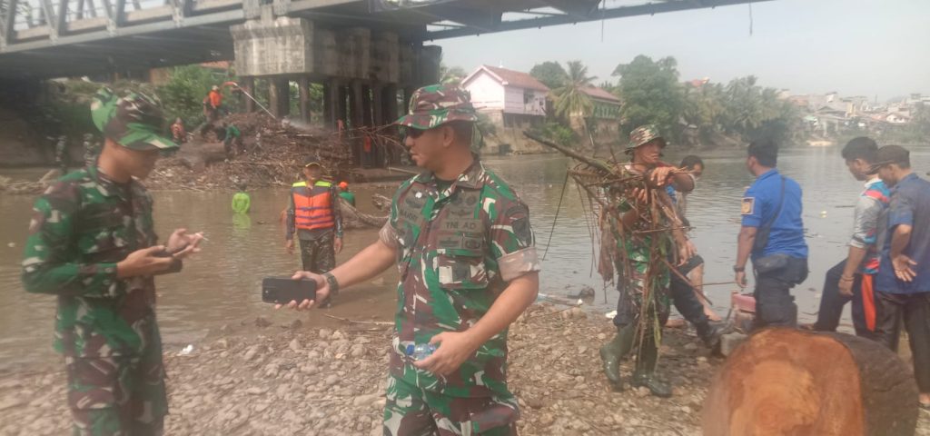 Ratusan personil TNI bersama OPD terkait di jajaran Pemkab OKU berjibaku turun ke Sungai Ogan untuk membersihkan sampah yang terperangkap di tiang-tiang penyangga jembatan. Foto Kanalberita.id / Edo