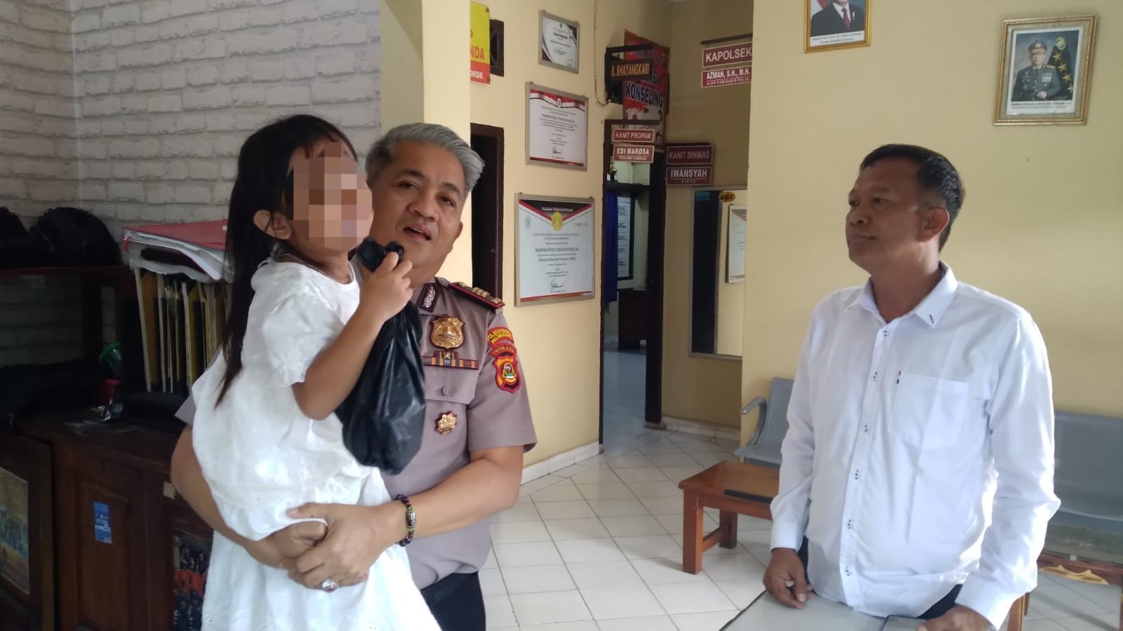 Kapolsek Baturaja Timur AKP Azwan S.H MH menyerahkan anak yang ditemukan tersesat kepada ornag tua kandungnya, Senin (9/2/2026) . Foto dokumen polisi.