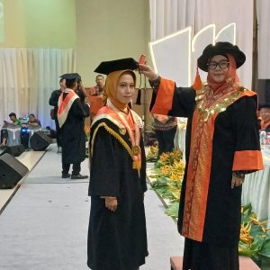 Rektor Unbara Ir Hj Lindawati MZ, MT saat memindahkan kucir kepada Riska Okta Pratiwi Program Magister sebagai peraih IPK tertinggi 3,82 di wisuda di Gedung Kesenian Baturaja. Kanalberita.id /Edo