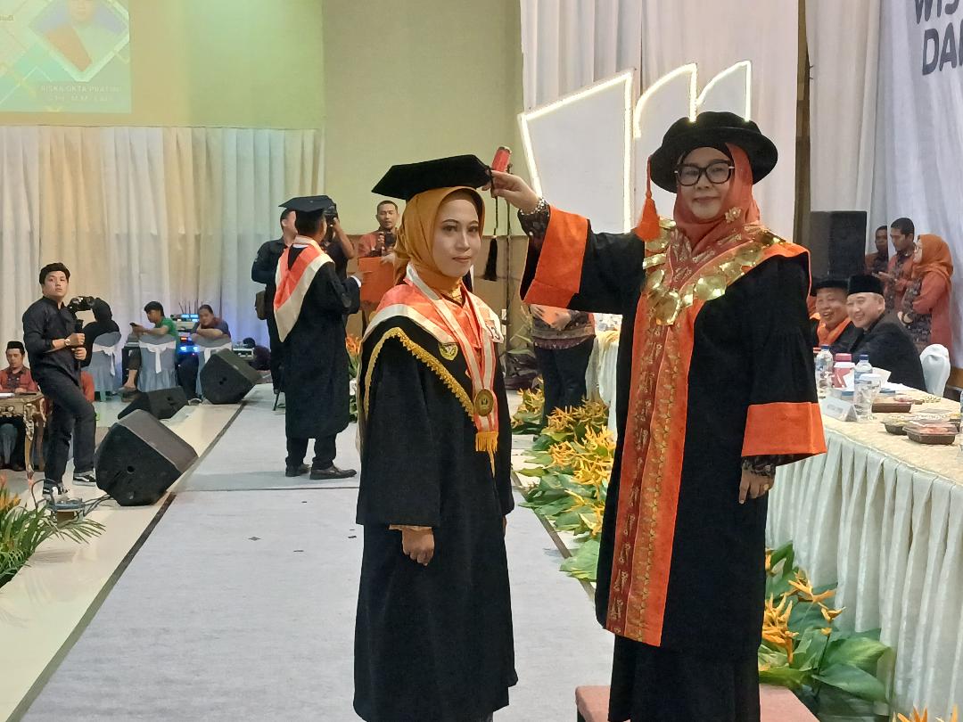 Rektor Unbara Ir Hj Lindawati MZ, MT saat memindahkan kucir kepada Riska Okta Pratiwi Program Magister sebagai peraih IPK tertinggi 3,82 di wisuda di Gedung Kesenian Baturaja. Kanalberita.id /Edo