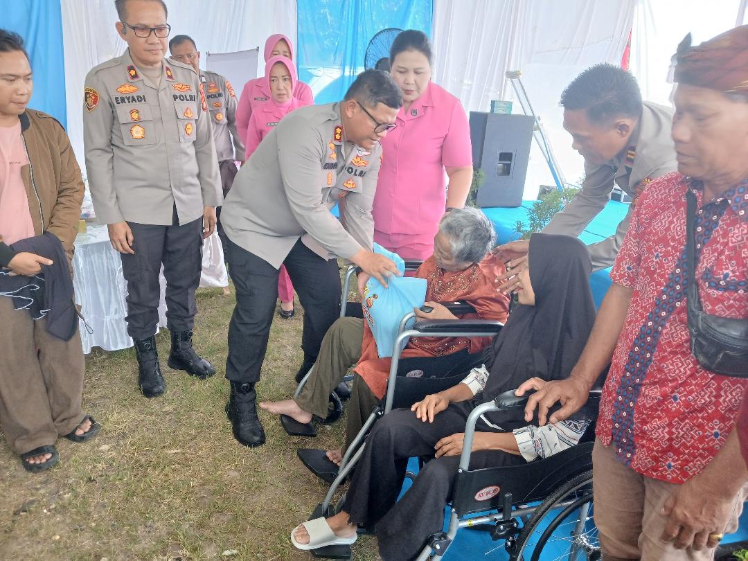 Kapolres OKU AKBP Endro Aribowo SIK MAP menyerahkan bantuan kursi roda kepada penerima manfaat di acara bakti kesehatan dalam rangka HUT Bhayangkara ke-80. Kanalberita.id / Edo