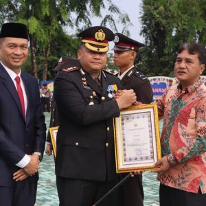 Kapolres OKU AKBP Endro Aribowo SIK MAP didampingi Sekda OKU Alva Elan SST M.PSDA berikan penghargaan kepada Kades Bumi Kawa usai upacara HUT Bhayangkara ke-80 Polres OKU. Kanalberita.id / Edo