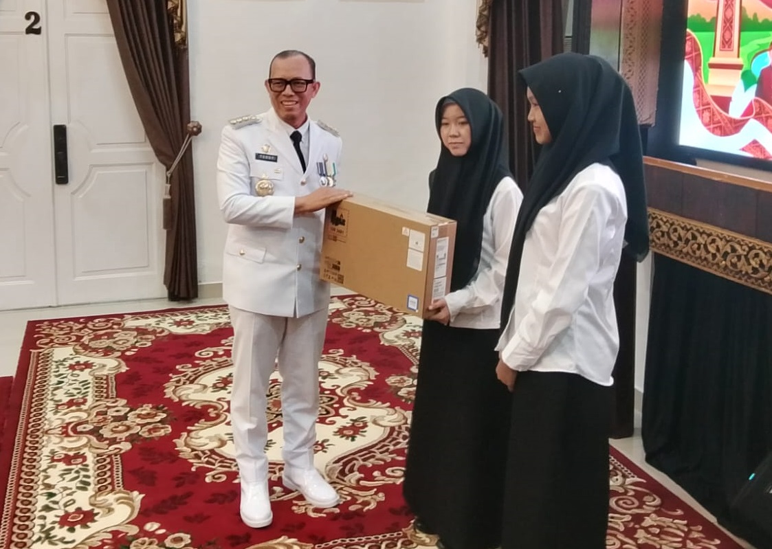 Bupati OKU H Teddy Meilwansyah SSTP MM MPd memberikan bantuan laptop kepada Mahasiswa Fakuktas Kedokteran Jalur Beasiswa Pemkab OKU Tahun 2026. Foto dokumen Kominfo Kabupaten OKU