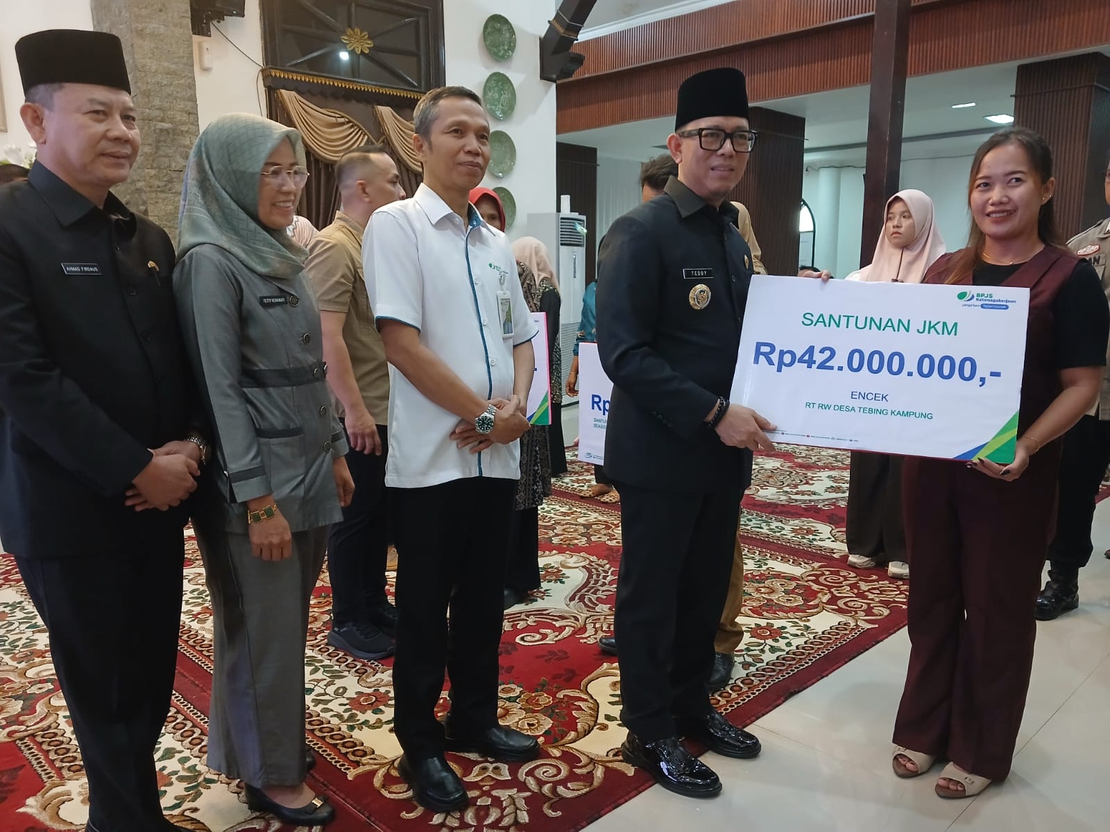 Bupati OKU H Teddy Meinlwansyah SSTP MM MPd didampingi Kepala BPJS Ketenagakerjaan OKU Riski menyerahkan santuanan kematian kepada ahli waris dan beasiswa ahli waris di Rumkab. Kanalberita.id / Edo