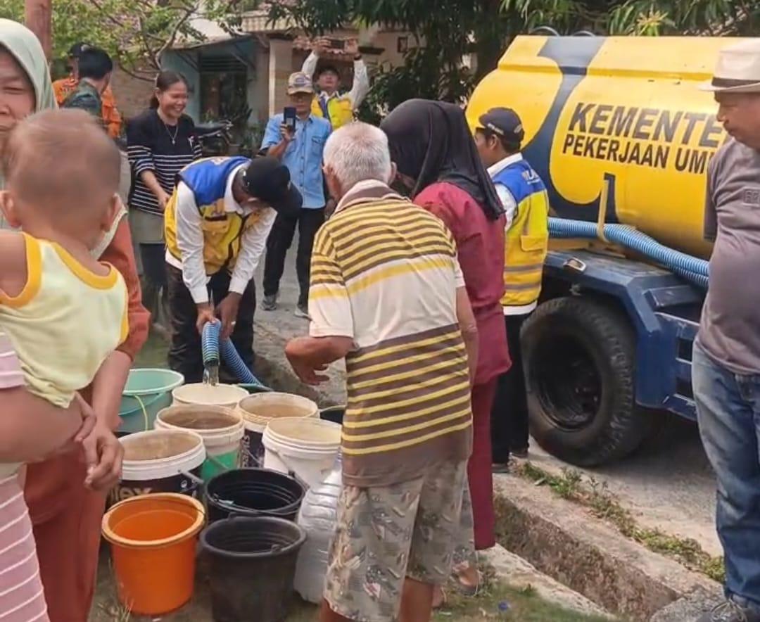 Warga yang tinggal di daerah sulit air dampak dari kemarau panjang nampak antre menunggu giliran wadah penampungan air diisi oleh petugas dari Pemkab OKU yang mentalurkan bantuan ari bersih grtasi. Kanalberita.id / Edo