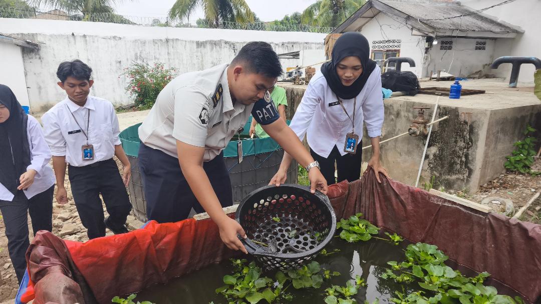 Peserta magang Kementerian Ketenagakerjaan di Rutan Baturaja bersama jajaran petugas dan warga binaan lakukan penyortiran (grading) ikan lele di area budidaya perikanan rutan. Foto dokumen Rutan Baturaja